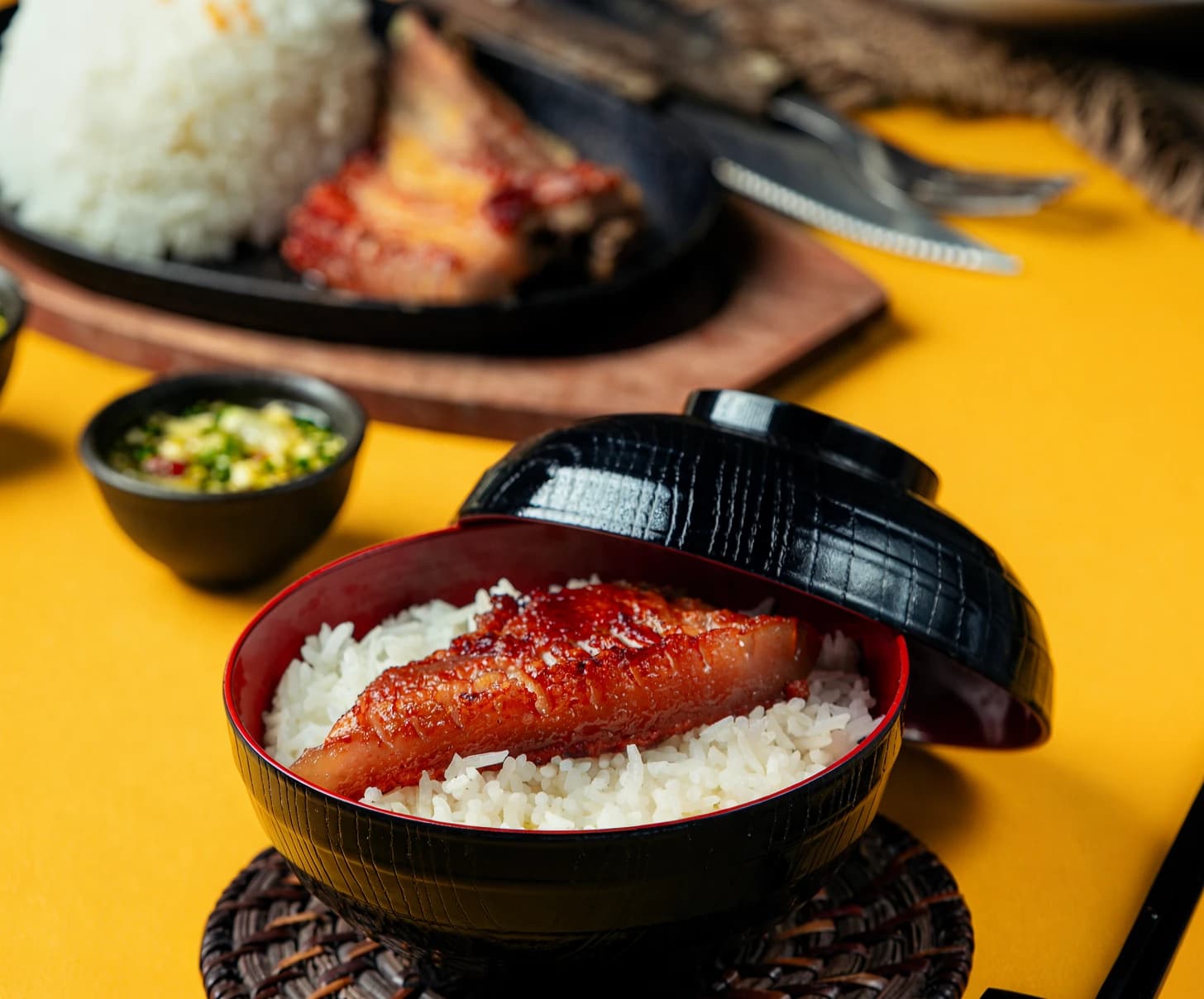 노란 배경에 놓인 장어구이 덮밥